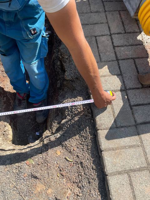 Measuring the trench works by hand with a tape measure